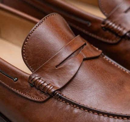 Classic brown penny loafers with iconic strap detail.