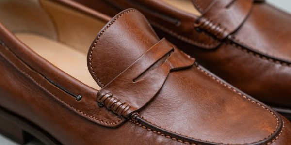 Classic brown penny loafers with iconic strap detail.