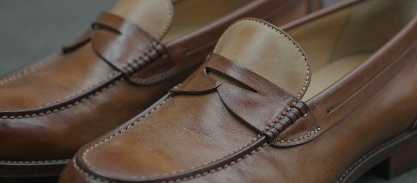 Classic two-tone penny loafers with brown and tan leather.