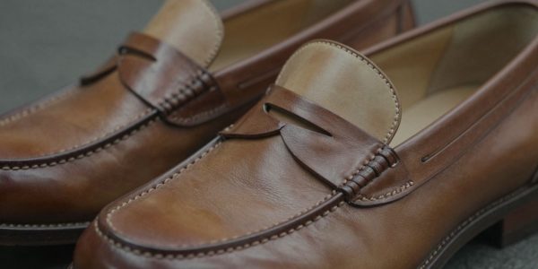 Classic two-tone penny loafers with brown and tan leather.