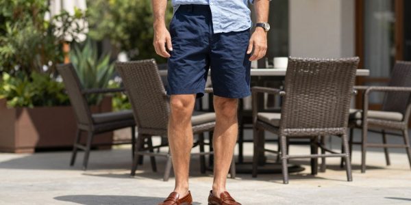 Man wearing penny loafers with shorts and a linen shirt.
