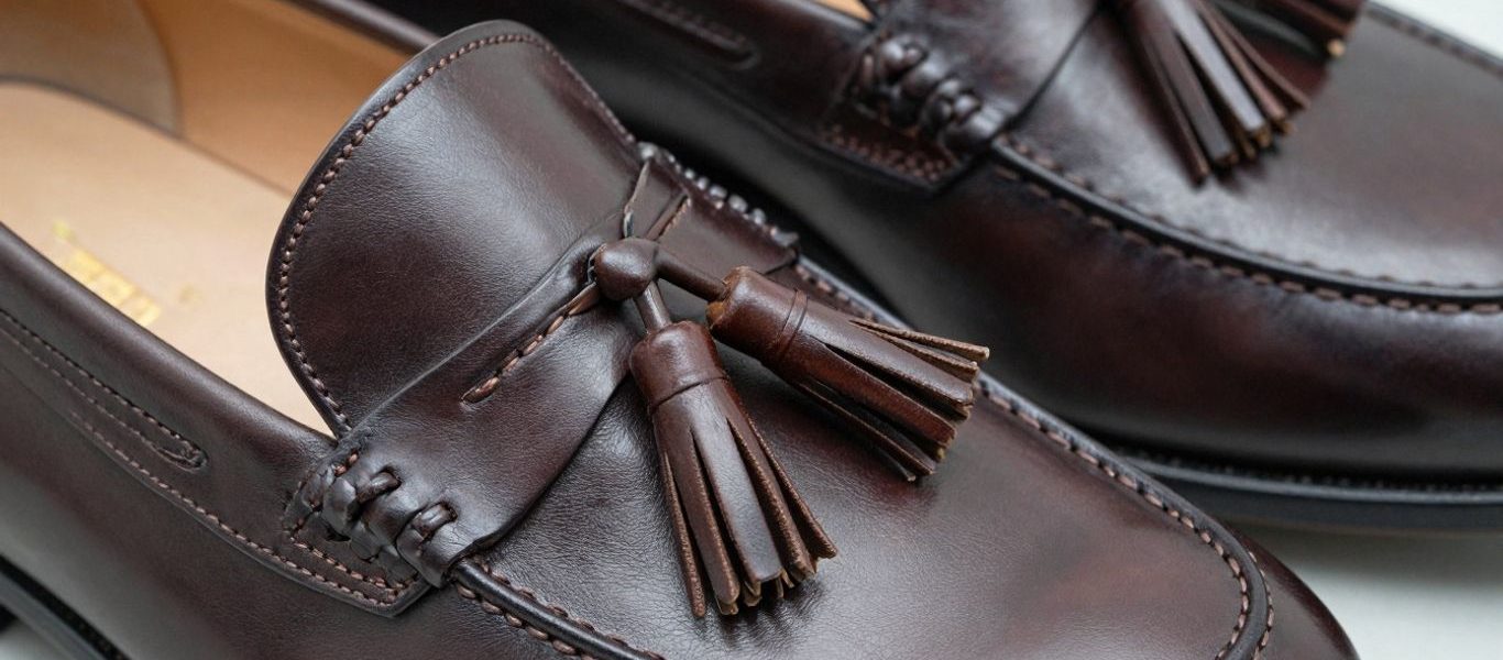 Close-up of premium dark brown leather tassel loafers.