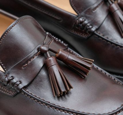 Close-up of premium dark brown leather tassel loafers.