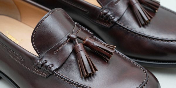 Close-up of premium dark brown leather tassel loafers.